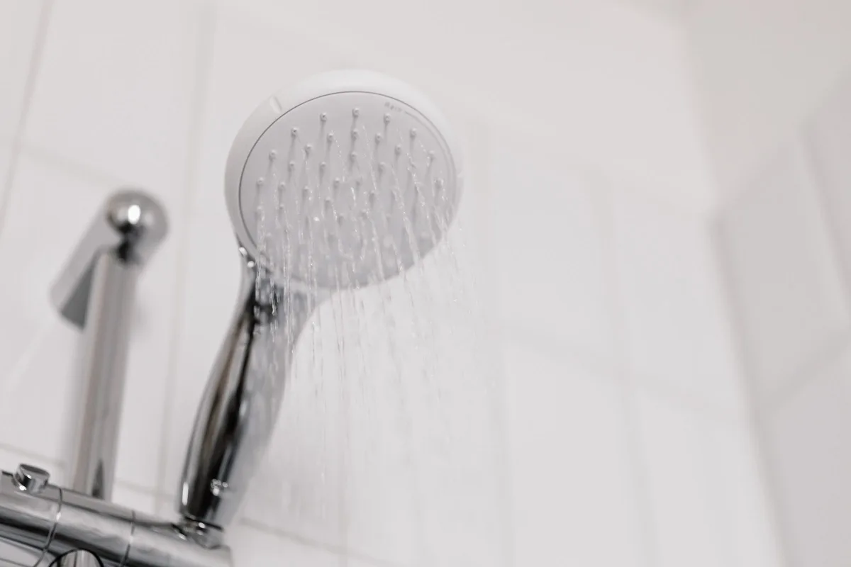 Hot water running from a chrome handheld shower