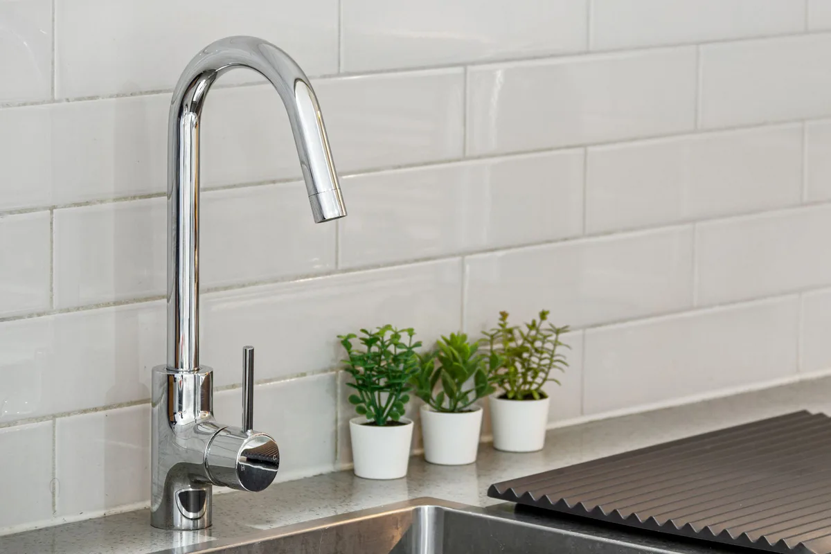 Chrome kitchen faucet over a stainless sink