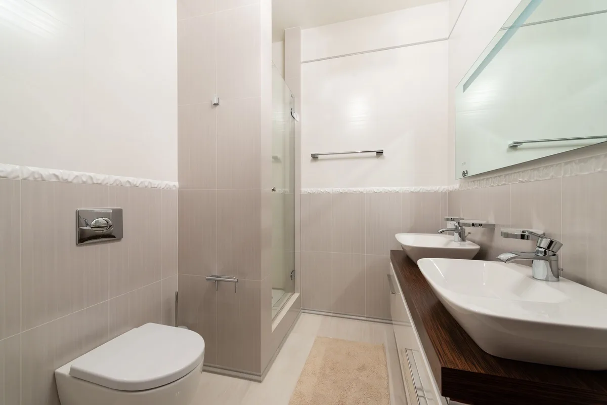 Bathroom with double vessel sinks and wall-hung toilet